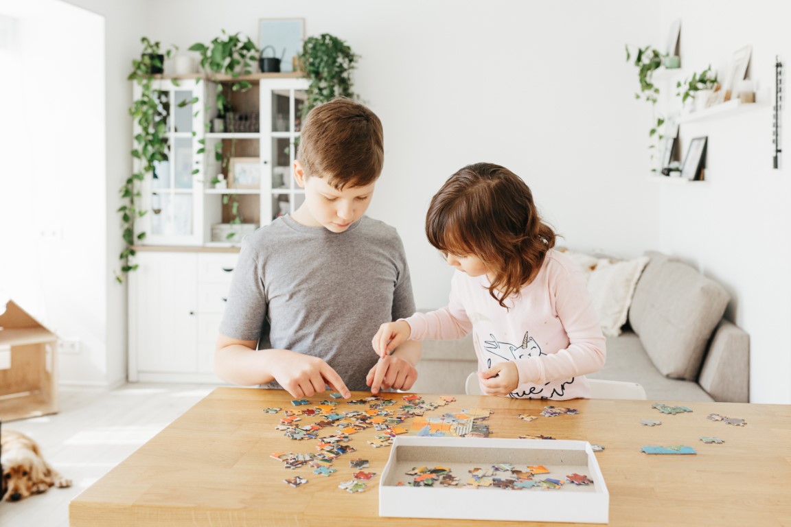 deux enfants qui se concentrent sur leur puzzle